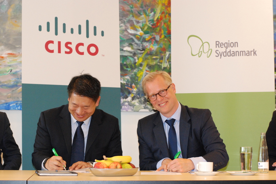 Billede af regionsrådsformand Carl Holst og vice president i Cisco, Hans Hwang, der underskriver aftalen her.