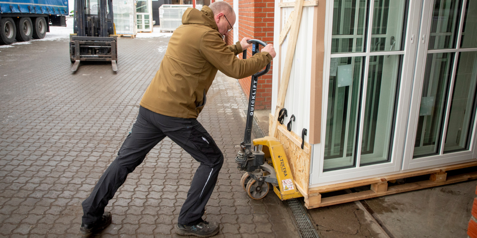 Foto af Lars Erik Povlsen, der flytter tunge vinduer med en palleløfter