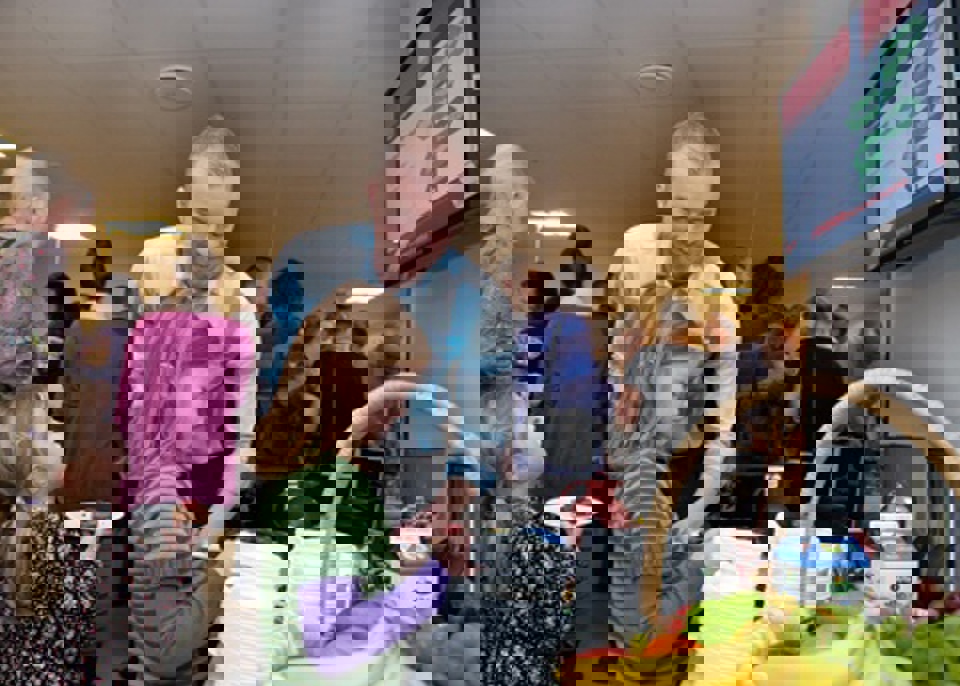 Gæsterne forsyner sig. På væggen ses et info-tv - et af Region  Syddanmarks tilbud til praktiserende læger, hvor patienter kan  læse om forskellige sundhedstilbud. 