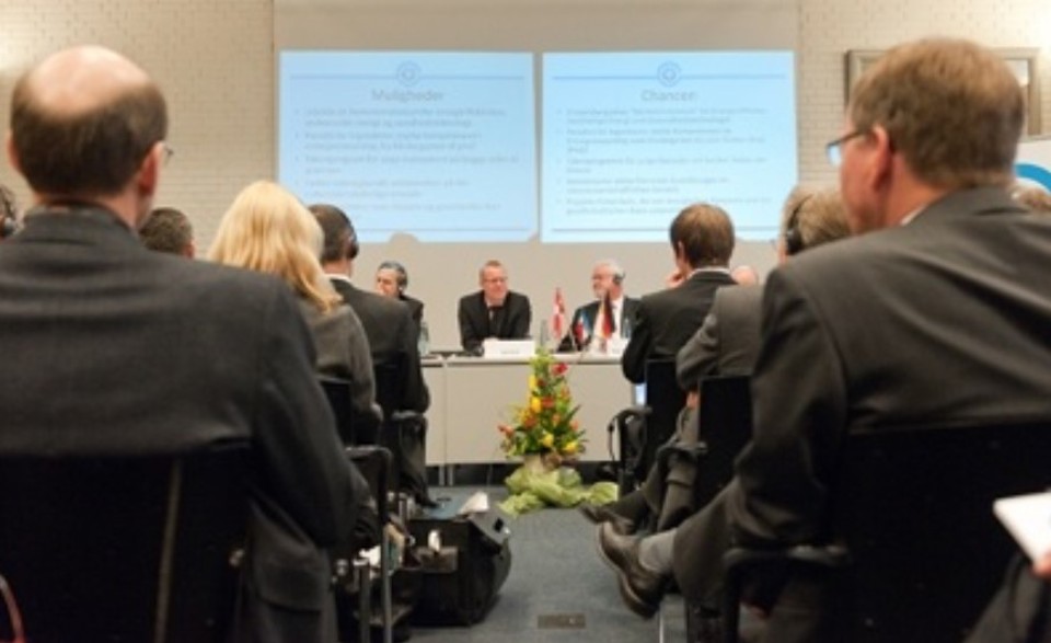 De mørkklædte herrer og damer lytter opmærksomt. I midten af billedet ses Carl Holst og Peter Harry Carstensen. Foto: Jørgen Diswal.