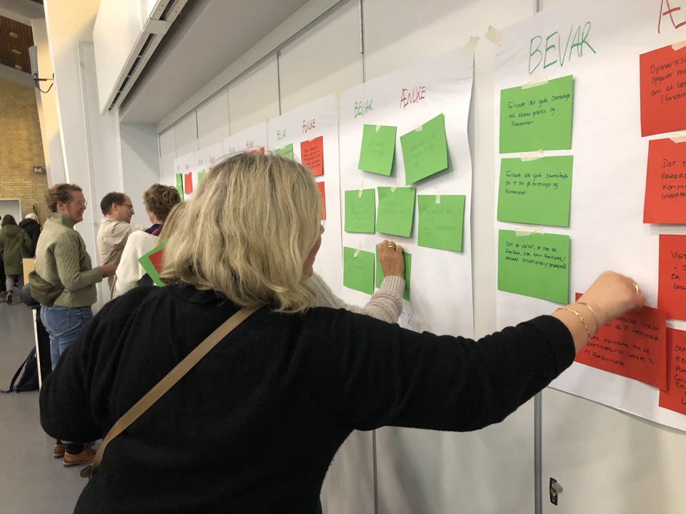 Kvinde hænger seddel op på plakat