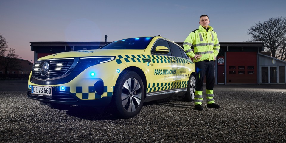 Paramediciner Morten Lorenzen står foran Ambulance Syds eldrevne akutbil.