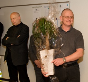 Blomst som tak til de læger, der tidligere har  betjent akutbilen. Nu bliver bilen bemandet med  en specialuddannet redder, og den gøres  døgndækket. Praktiserende læge Lars Gehlert  Johansen fra lægehuset i Rødding tager i mod. I baggrunden ses borgmester i Vejen Kommune,  Egon Fræhr (V).