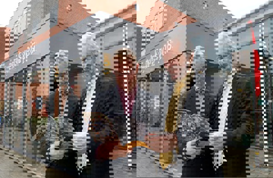 Carl Holst og Bjarne Normark udenfor SVS i Esbjerg med jubilæumsskriftet i hånden Sydvestjysk Sygehus fylder 100 år. I hånden holder Carl Holst og Bjarne Normark et jubilæumsskrift. Du kan se skriftet ved at  klikke på linket nederst på siden.