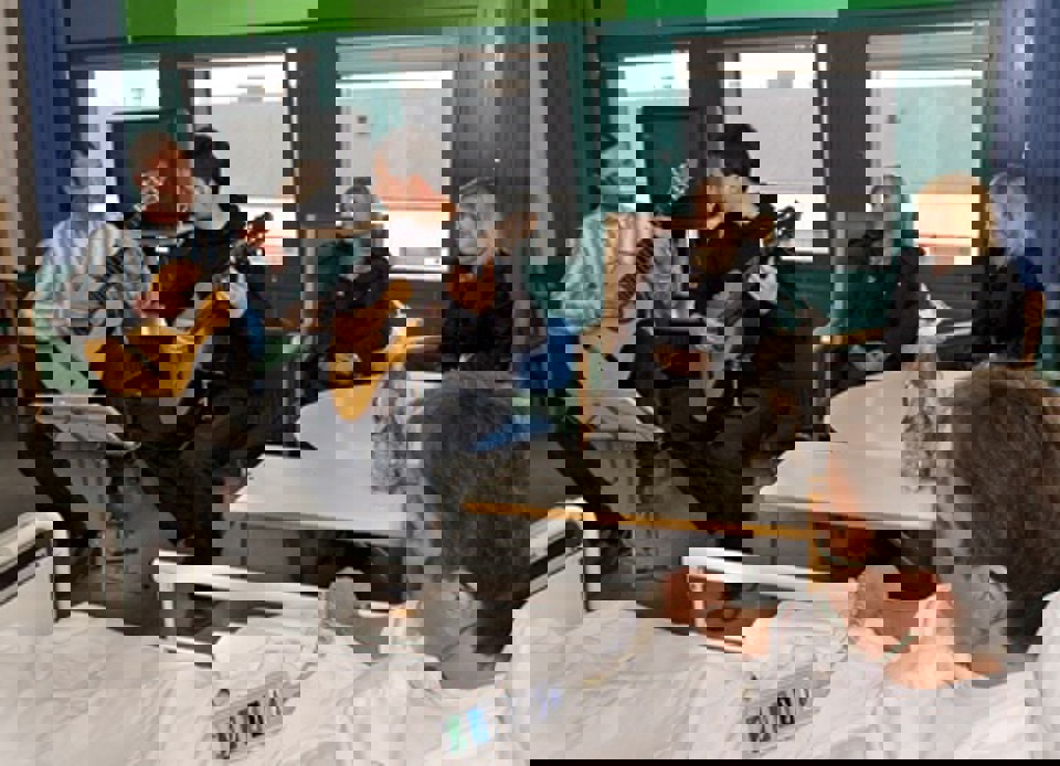 Carina Christensen lytter til musik På en af sengestuerne lod kulturministeren sig besnære af  latinske guitarrytmer fra Thomas Bøgh Jensen og Søren Dahl  Nielsen.