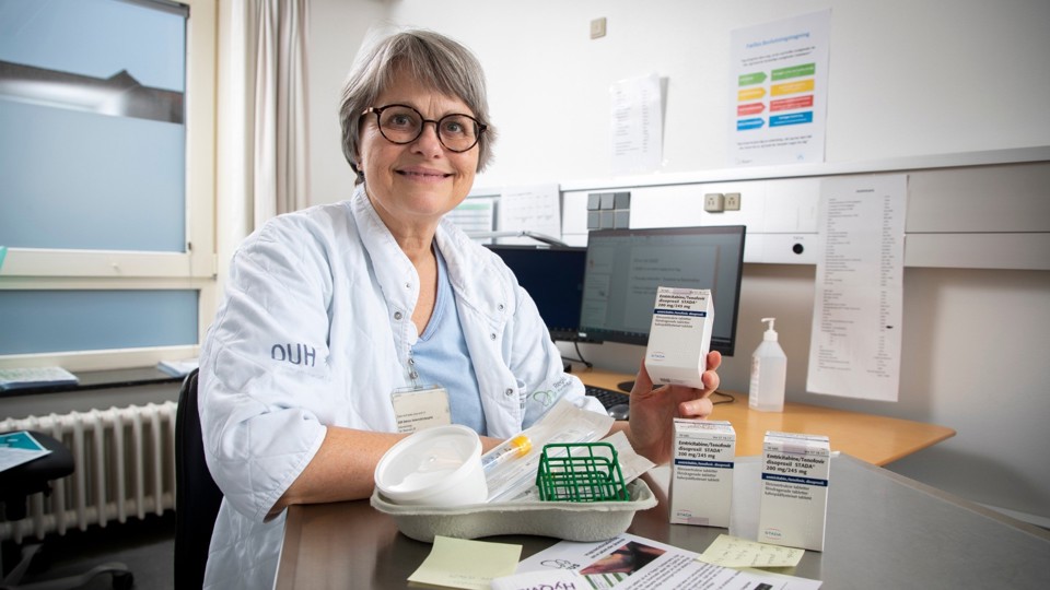 Sygeplejerske Helle Møller ved et bord med medicin