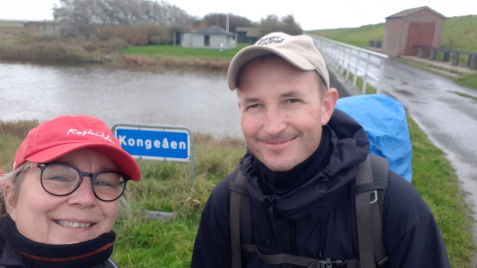 Kvinde og mand med kasketter og jakker på fotograferet med selfie foran Kongeåen.